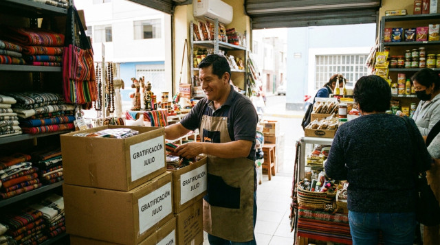 Un emprendedor peruano en su pequeño negocio organizando mercadería nueva comprada con su gratificación de julio